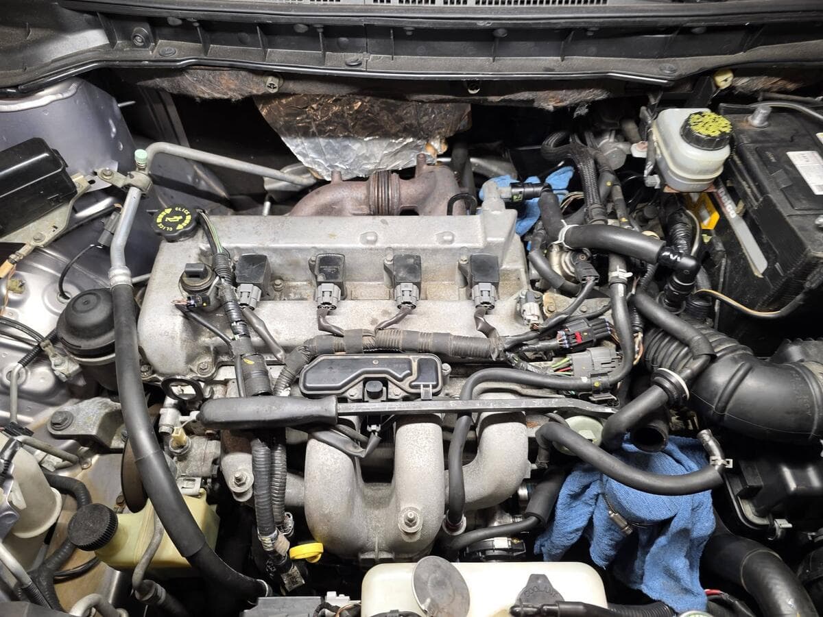 Four-cylinder engine bay with the ignition coils exposed for diagnosis